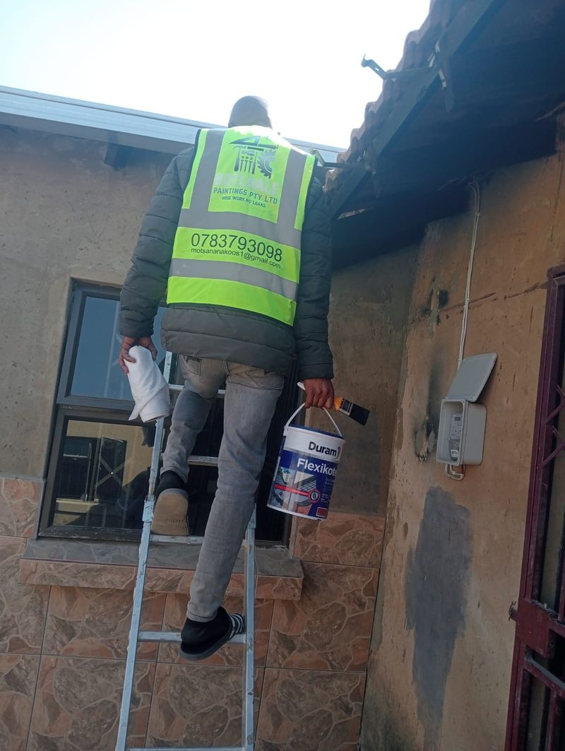 Botlhale team member on site with waterproofing paint